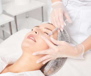 A woman receives a facial filler injection under her eye